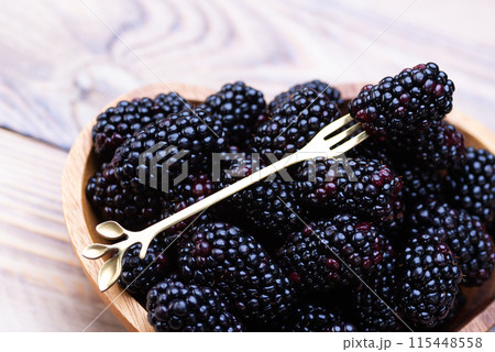 Fresh blackberries on a wooden plate 115448558