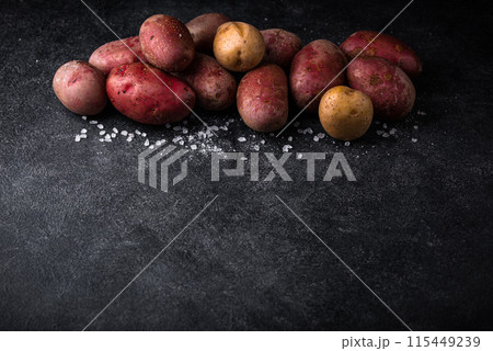 Raw uncooked potato on dark table 115449239