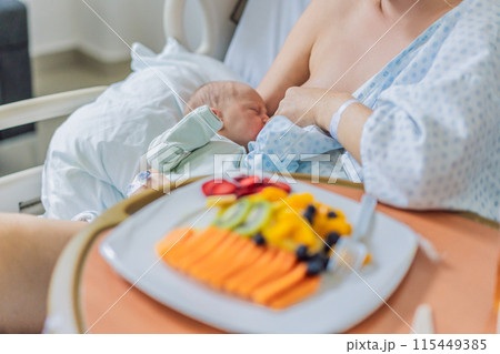 A woman breastfeeds her baby in the hospital while simultaneously having lunch herself. This moment of multitasking illustrates the balance between motherhood and self-care, emphasizing maternal A woman breastfeeds her baby in the hospital while simultaneously having lunch herself. This moment of multitasking illustrates the balance between motherhood and self-care, emphasizing maternal 115449385