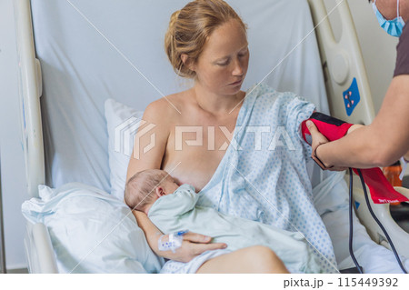 A woman in a hospital breastfeeds her baby while a nurse checks the mother s health. The nurturing moment showcases the bond between mother and child, while the attentive nurse ensures the mother's A woman in a hospital breastfeeds her baby while a nurse checks the mother s health. The nurturing moment showcases the bond between mother and child, while the attentive nurse ensures the mother's 115449392