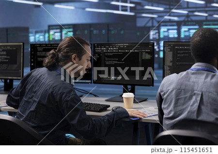 Coworkers in data center workspace running system diagnostic tests to do repairments. IT experts at PC desk in server hub deploying error checking utilities to fix network issues 115451651