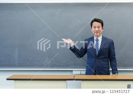 黒板を指し示す教師 115451727