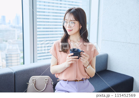 オフィスのソファでコーヒーを飲む女性 115452569