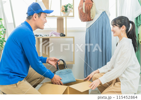 小物・雑貨・バッグを荷造りする引越し業者・配達員の男性（引越し・リサイクルショップ・質屋） 115452864
