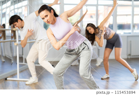 Woman with team of young like-minded people learn to dance modern dances Woman with team of young like-minded people learn to dance modern dances 115453894
