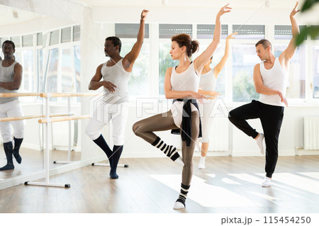 Graceful woman leading ballet class with adult amateur dancers 115454250