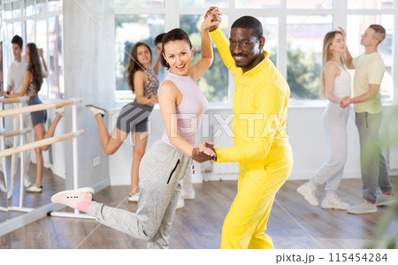 Couple male and girl rehearsing pair latino dance in studio Couple male and girl rehearsing pair latino dance in studio 115454284