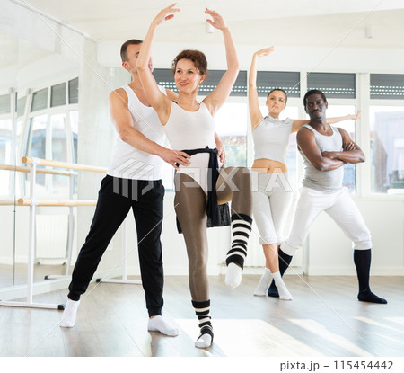Pair of ballet dancers mastering supports during group rehearsal 115454442