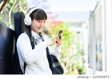 ギターを背負う女子高生　スマホ 115454873