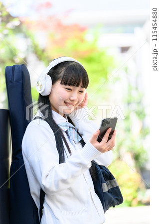 ギターを背負う女子高生　スマホ 115454880
