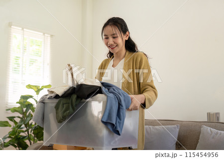 Smiling Volunteer Donation Clothes at Home. Community Service, Charity, and Generosity Concept 115454956