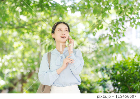 新緑の中で電話をする女性 新緑の中で電話をする女性 115456607