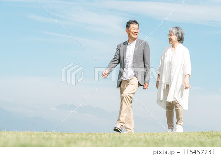 公園・旅行先を話しながら歩く高齢者夫婦(シニア・男女) 公園・旅行先を話しながら歩く高齢者夫婦(シニア・男女) 115457231