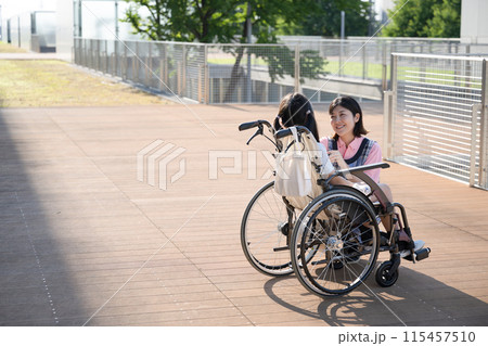 車椅子に乗る子供と介護や補助をする介護士や看護師　全身 115457510