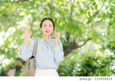スマホで電話をしながら手を振る女性 115458914