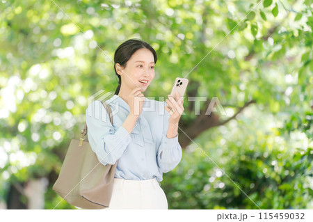 スマホを持つ笑顔の女性 115459032