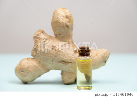 Natural Ginger Essential Oil in a Glass Bottle on a Grey Blue Background. 115461946