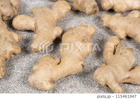 Fresh ginger roots on gray stone background close-up. 115461947