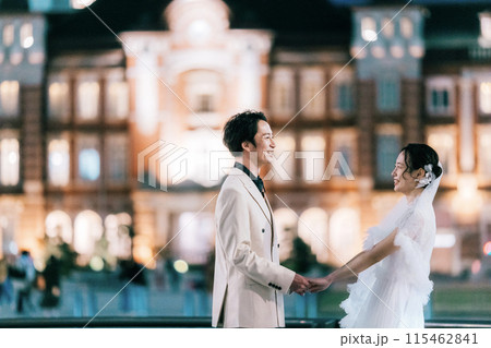 夜の東京駅でフォトウェディングを楽しむカップル 115462841