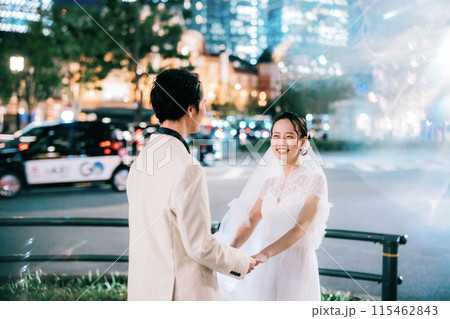 夜の東京駅でフォトウェディングを楽しむカップル 115462843