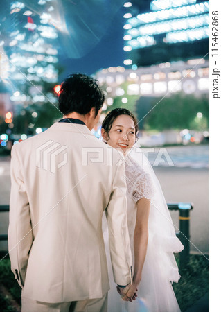 夜の東京駅でフォトウェディングを楽しむカップル 115462868