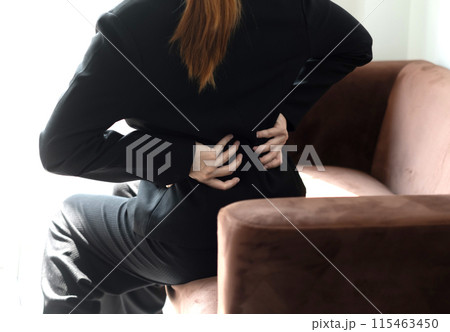 Woman having back body pain during work long time. stretching to relax and relax while working hard at the office 115463450