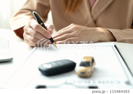 Car dealer businesswoman signing car insurance document or lease paper. Car loan and insurance concept 115464303