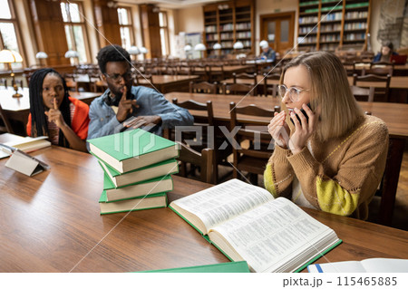 Young people in the library, blonde woman talking on the phone Young people in the library, blonde woman talking on the phone 115465885