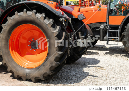 Row of red agricultural tractors for sale. 115467158