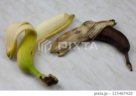 Fresh and spoiled banana on white table, rotten unpleasant fruit lies next to fresh juicy banana, unhealthy fruit food Fresh and spoiled banana on white table, rotten unpleasant fruit lies next to fresh juicy banana, unhealthy fruit food 115467420
