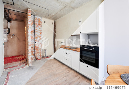 Photo collage of apartment before and after restoration or refurbishment. Comparison of old room and new kitchen with parquet floor, doorway, kitchen counter and white walls. Home renovation concept. Photo collage of apartment before and after restoration or refurbishment. Comparison of old room and new kitchen with parquet floor, doorway, kitchen counter and white walls. Home renovation concept. 115469973