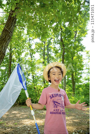 雑木林でセミの抜けがらを服に付けて笑う男の子 115471051