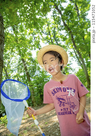 雑木林でセミの抜けがらを服に付けて笑う男の子 115471052