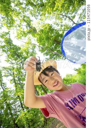 雑木林でカブトムシを持つ男の子 115471056
