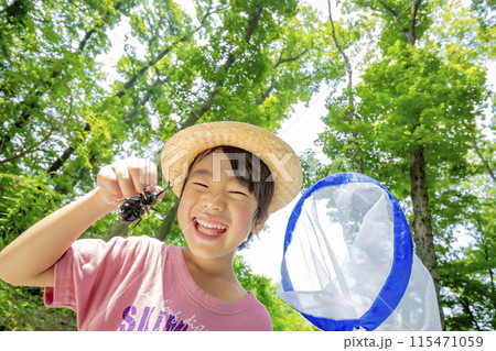 雑木林でカブトムシを持つ男の子 115471059