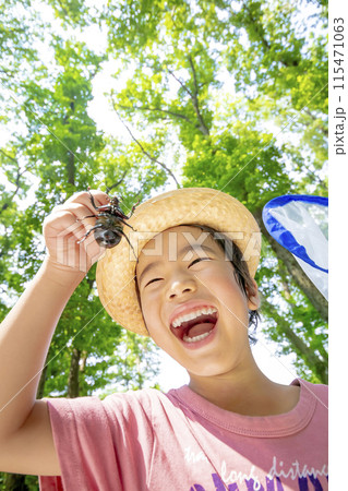 雑木林でカブトムシを持つ男の子 115471063