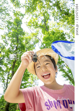 雑木林でカブトムシを持つ男の子 115471064