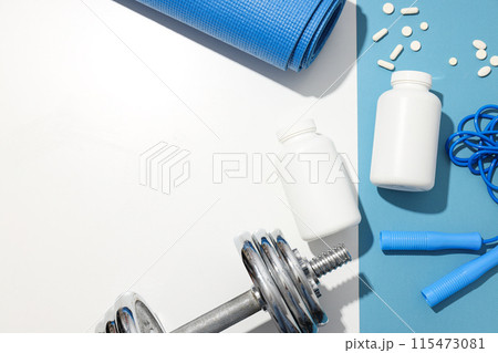 Plastic jars with pills and sport equipment on blue and white background, space for text Plastic jars with pills and sport equipment on blue and white background, space for text 115473081