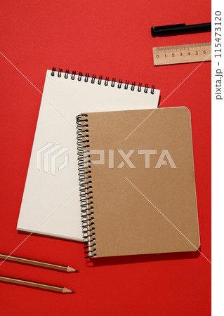 Two notebooks with stationery on a red background 115473120