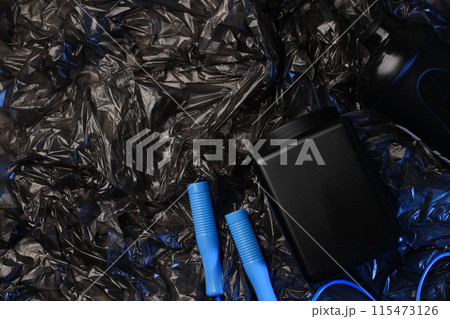Jump rope, black plastic jar and bottle on dark background, space for text 115473126
