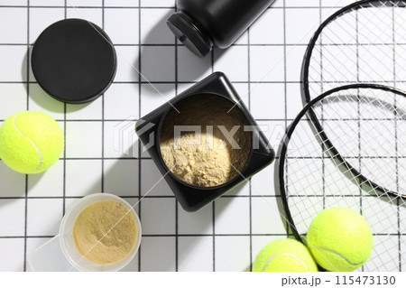 Black plastic jars, rackets and tennis balls on light background, top view Black plastic jars, rackets and tennis balls on light background, top view 115473130