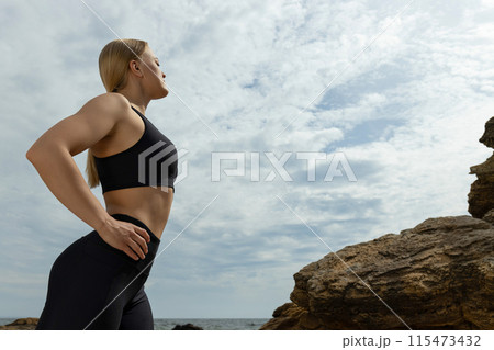 Young blonde woman in sportswear and rocks outdoors, space for text Young blonde woman in sportswear and rocks outdoors, space for text 115473432