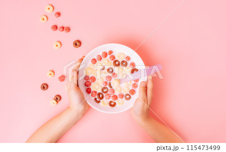 Breakfast of corn rings with milk on pink background Breakfast of corn rings with milk on pink background 115473499