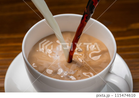 カップに牛乳とコーヒーを入れてつくるカフェオレ 115474610