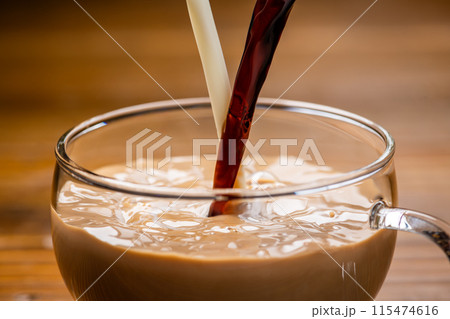 ガラスのカップに牛乳とコーヒーを入れてつくるカフェオレ 115474616