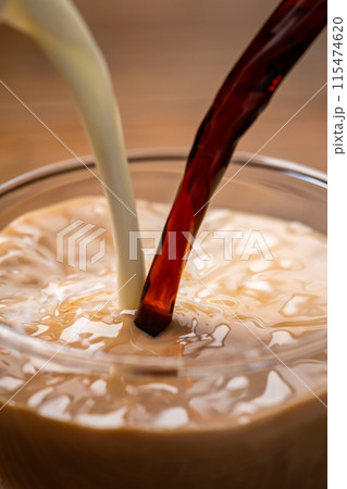 ガラスのカップに牛乳とコーヒーを入れてつくるカフェオレ 115474620