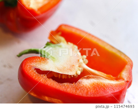 A red bulgarian pepper, paprika vegetable, cut, lies on a white background, on a table. Healthy nutrition, vegetarianism, crop production, vegetable garden 115474693
