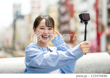 都会の繁華街で自撮り撮影をする若くて可愛い女性｜大阪観光イメージ｜大阪府道頓堀｜戎橋（えびすばし） 115474696