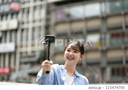 都会の繁華街で自撮り撮影をする若くて可愛い女性｜大阪観光イメージ｜大阪府道頓堀｜戎橋（えびすばし） 115474705