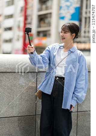 都会の繁華街で自撮り撮影をする若くて可愛い女性｜大阪観光イメージ｜大阪府道頓堀｜戎橋（えびすばし） 115474707